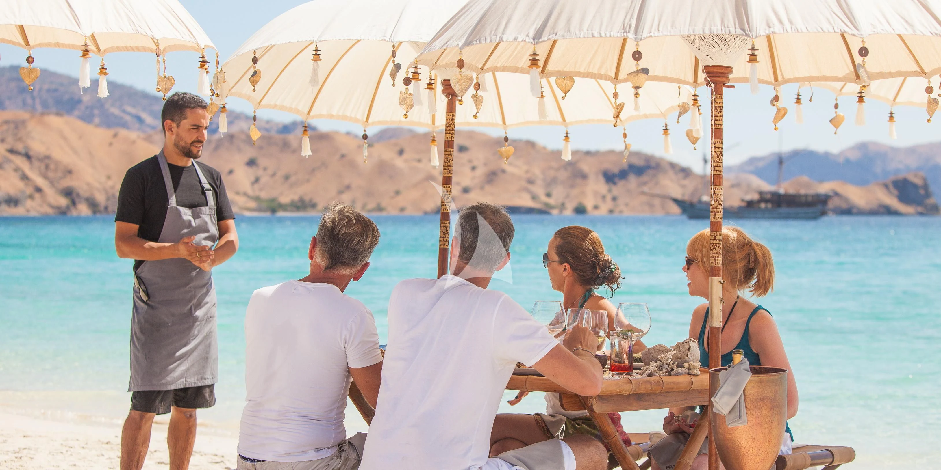 a group of people sitting on a boat at a bar aboard PRANA Yacht for Charter