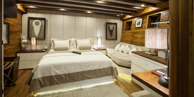 a room with a bed and a desk aboard PRANA Yacht for Charter