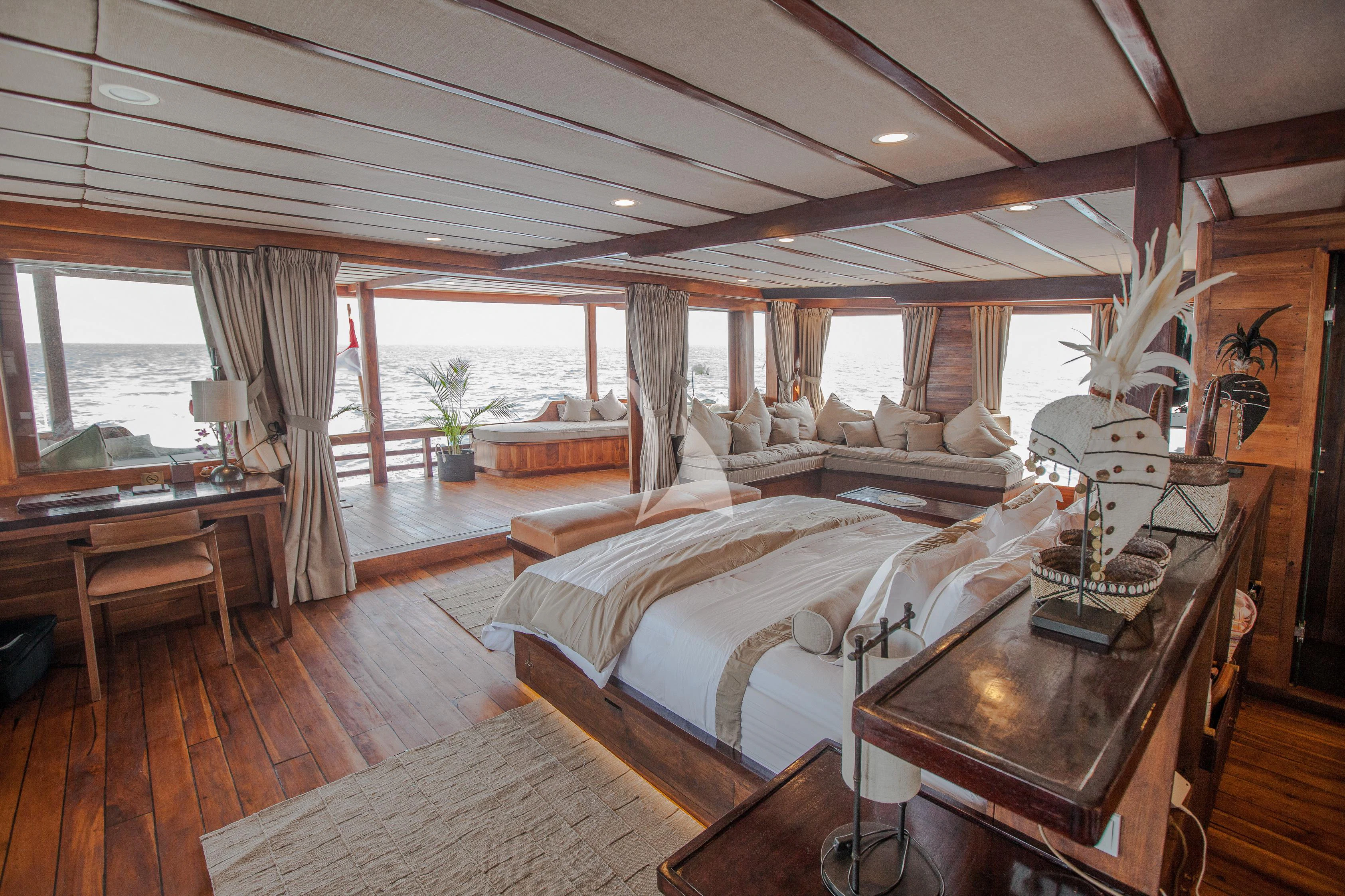 a room with a bed and a table aboard PRANA Yacht for Charter
