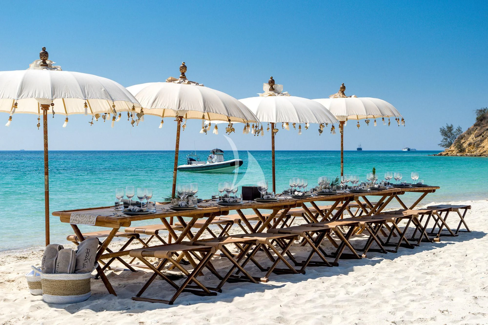 a group of umbrellas sit on a beach aboard PRANA Yacht for Charter