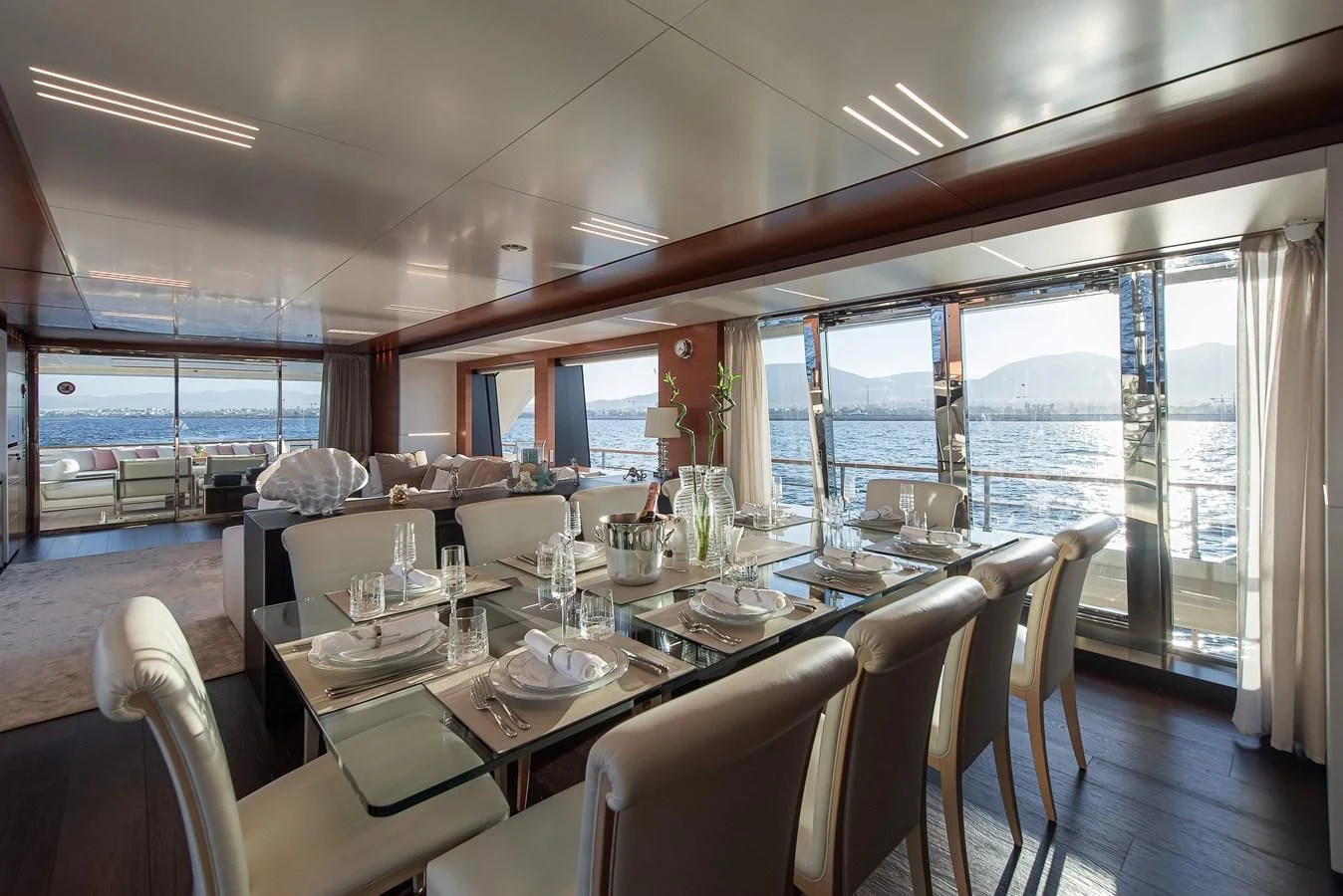 a dining table with chairs and a view of the ocean aboard NO SAUCE Yacht for Sale