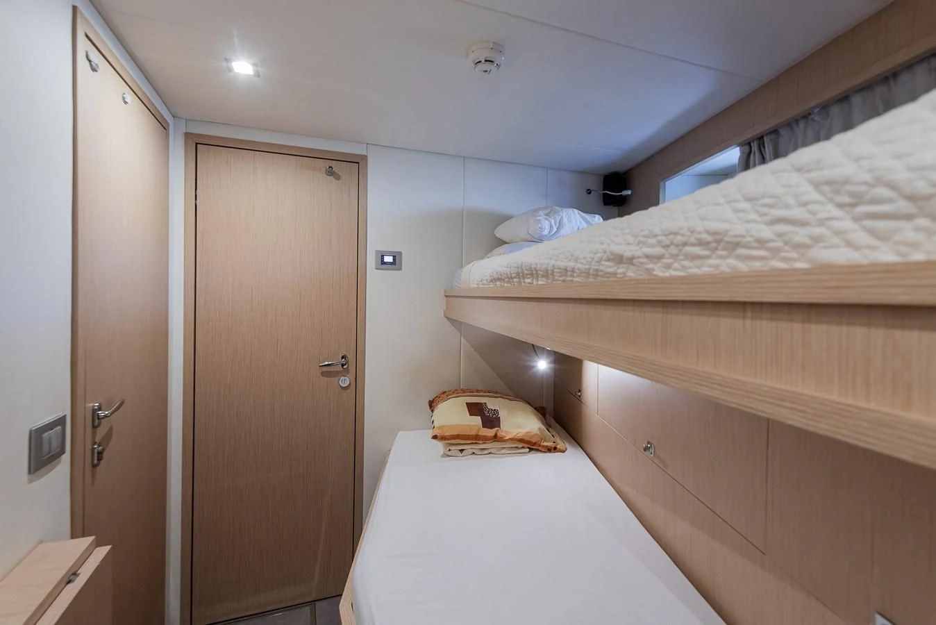 a bedroom with a bed and a door aboard NO SAUCE Yacht for Sale