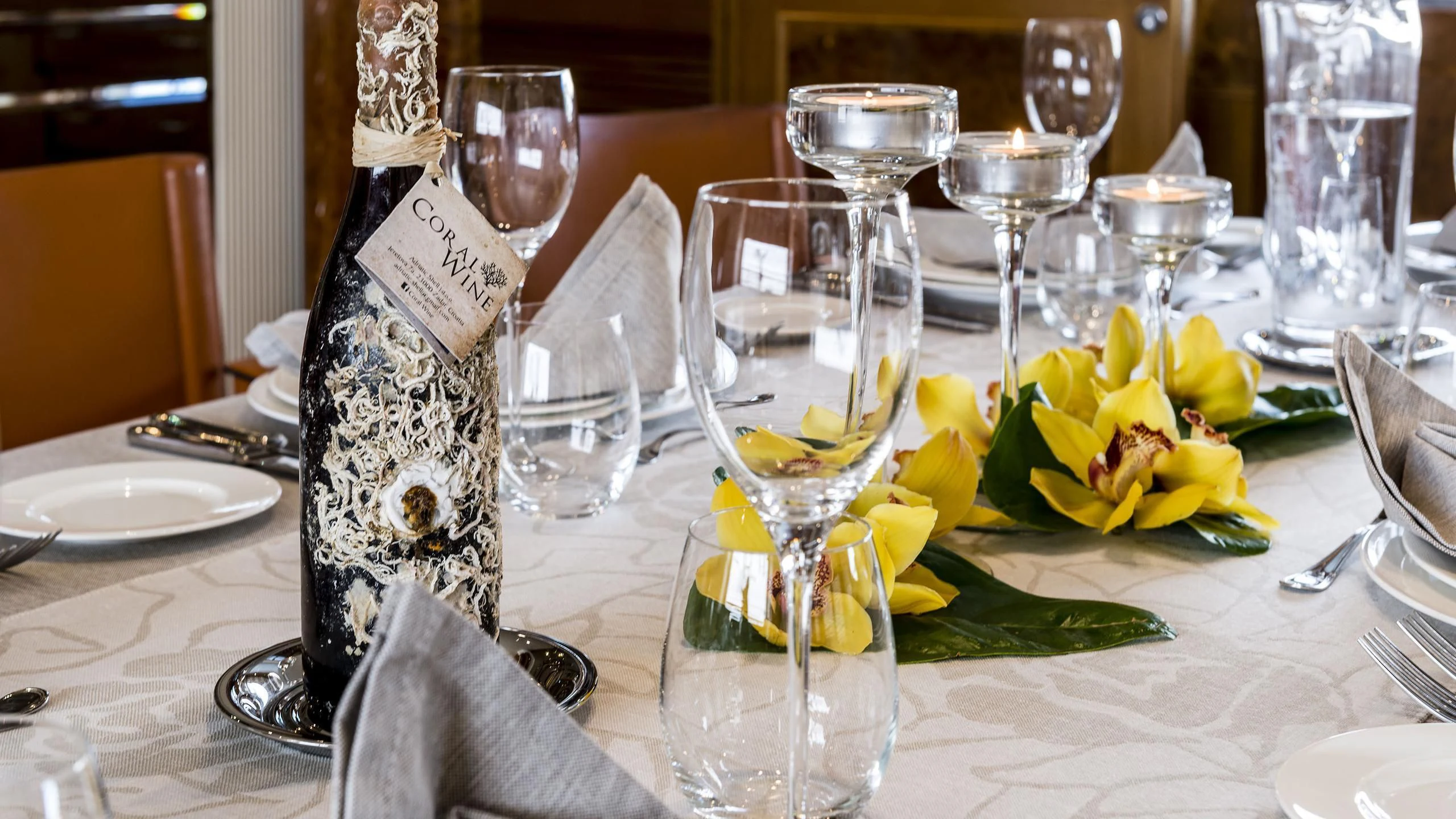 a table with wine glasses and napkins on it aboard DESAMIS B Yacht for Sale