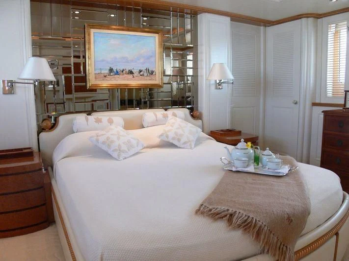a bed with a tray of food on it aboard DESAMIS B Yacht for Sale