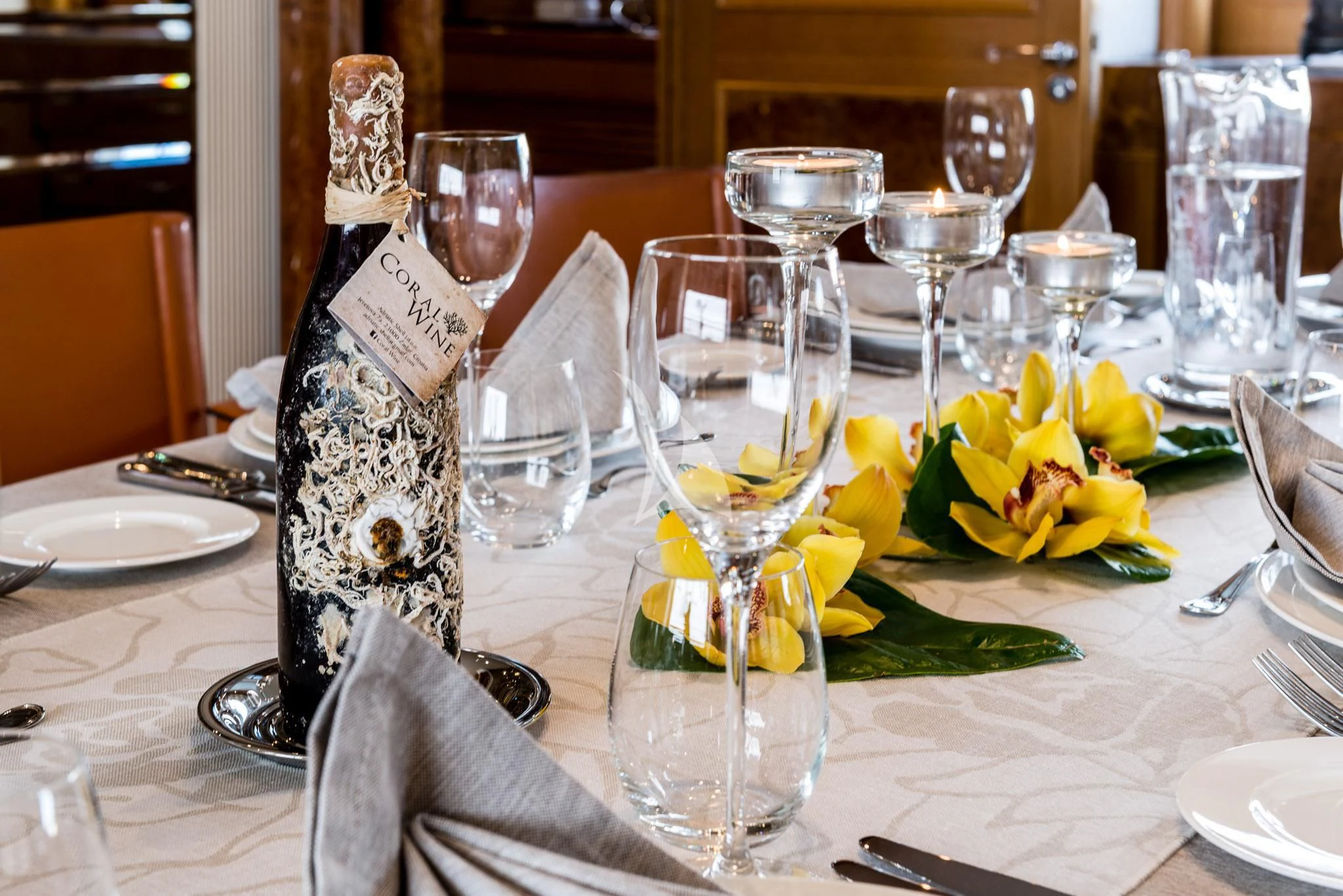 a table with wine glasses and flowers aboard DESAMIS B Yacht for Sale