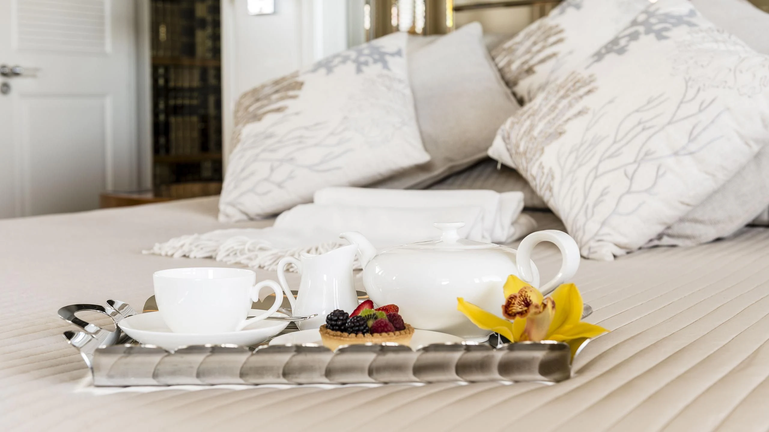 a plate of food and a cup on a bed aboard DESAMIS B Yacht for Sale