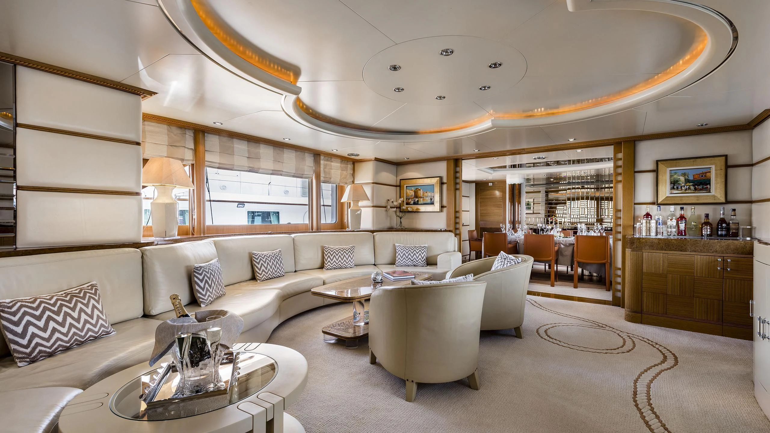 a living room with a large white couch and a large mirror aboard DESAMIS B Yacht for Sale