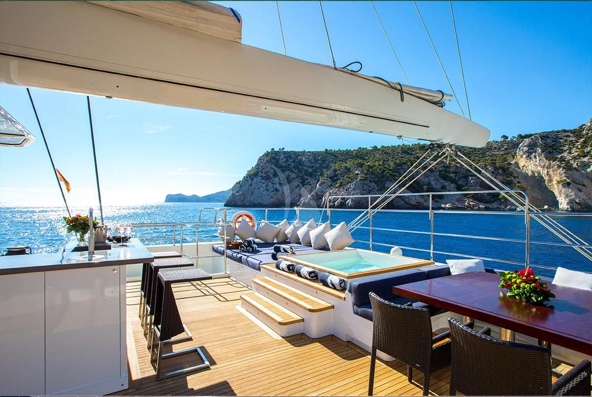 a deck with a view of the ocean and mountains aboard MASHUA BLUU Yacht for Sale