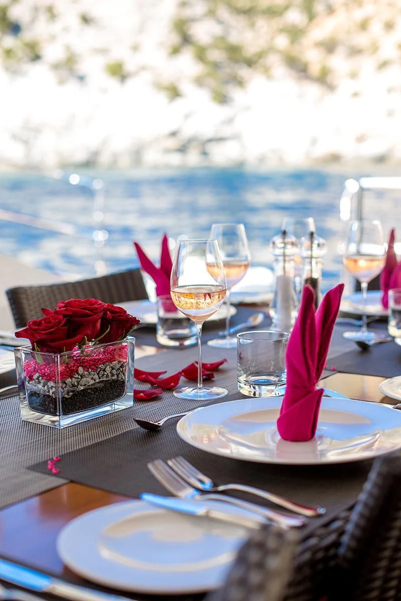 a table with plates and glasses on it aboard MASHUA BLUU Yacht for Sale
