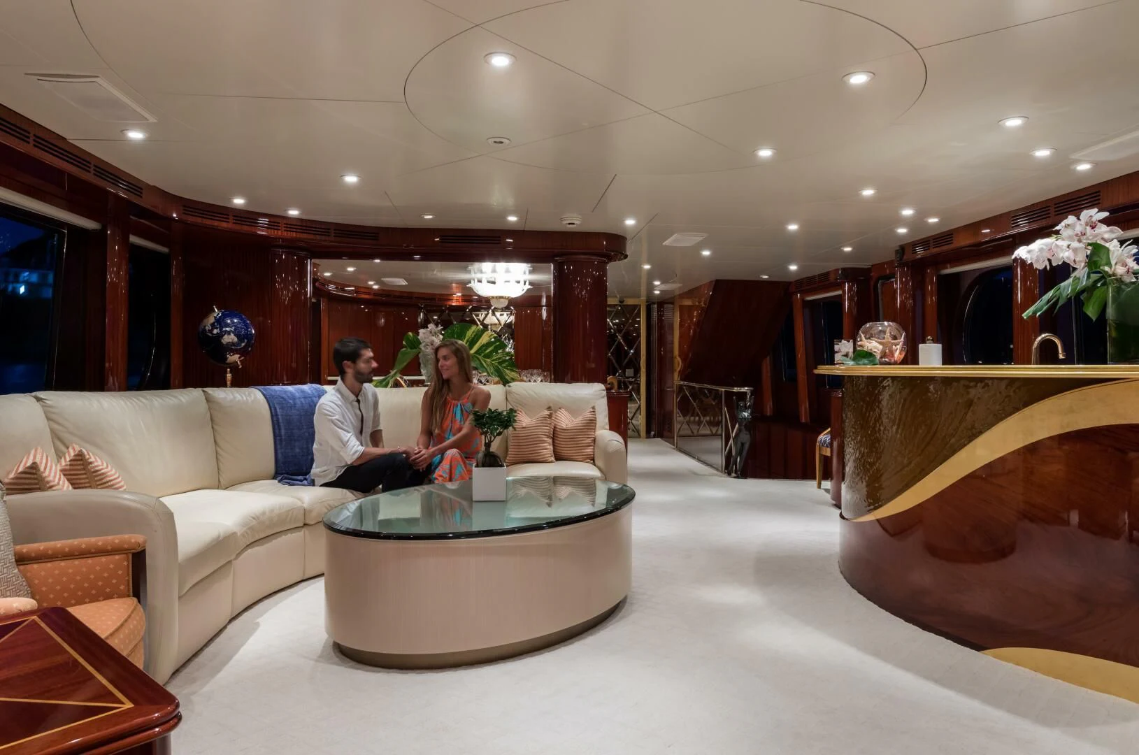 a man and woman sitting on a couch in a living room aboard TOUCH Yacht for Sale