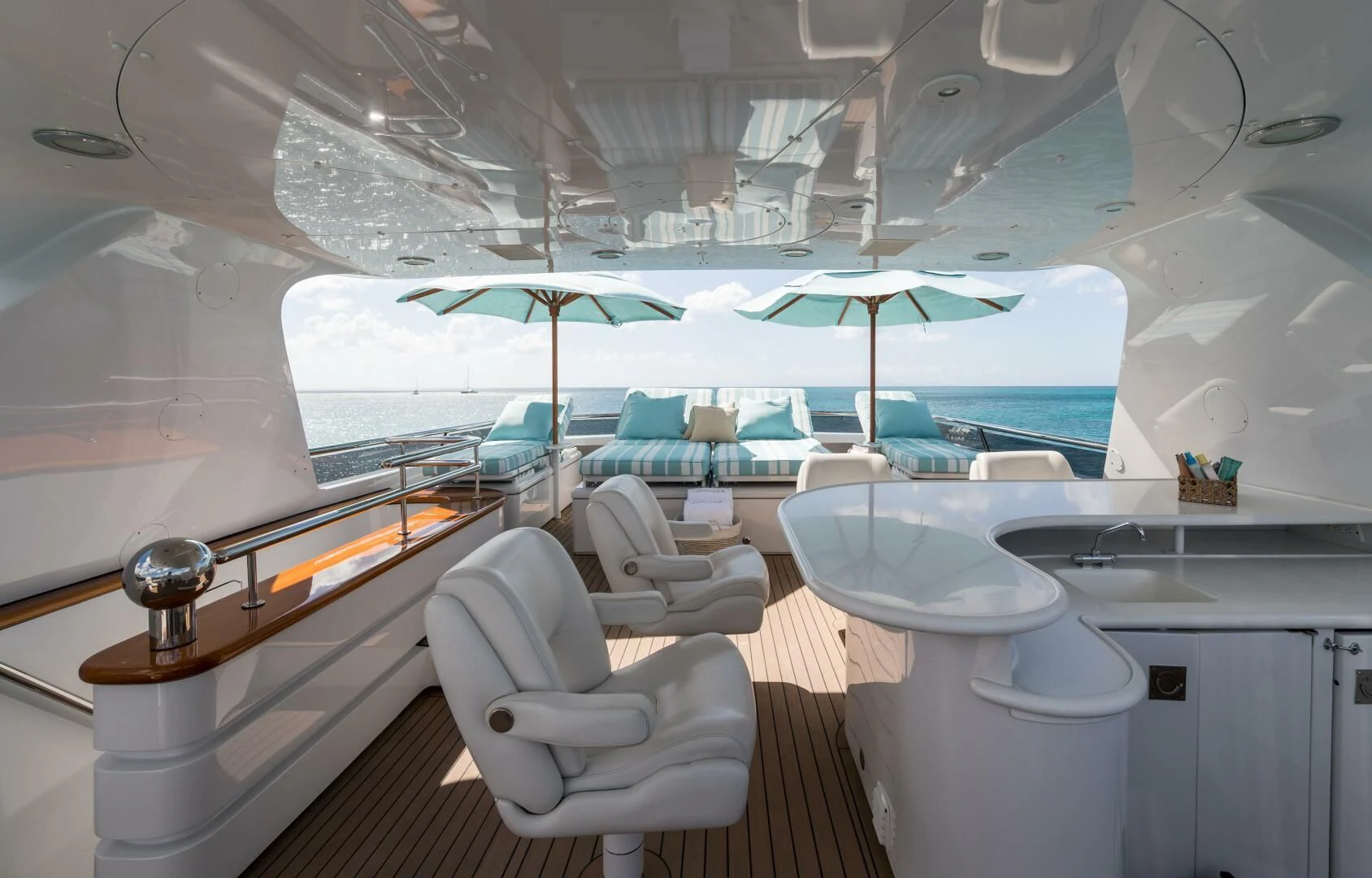 a room with a large window and a table with chairs and an umbrella aboard TOUCH Yacht for Sale