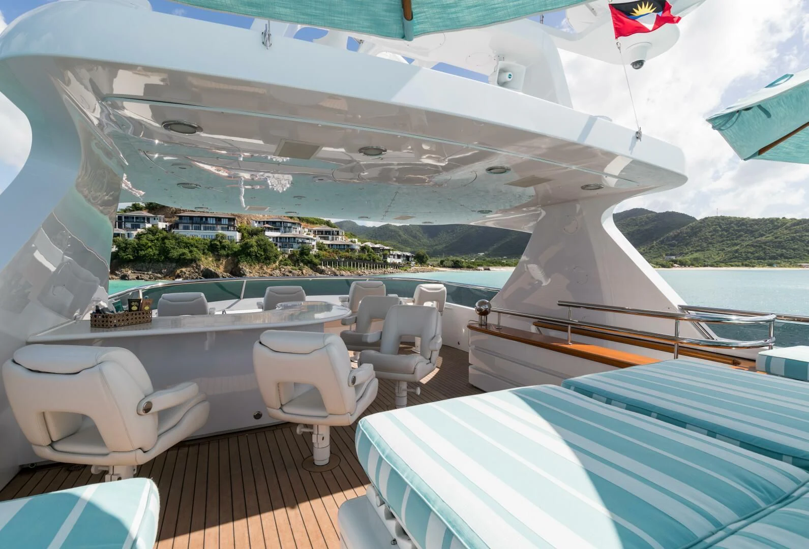 a deck with chairs and a body of water and a beach aboard TOUCH Yacht for Sale