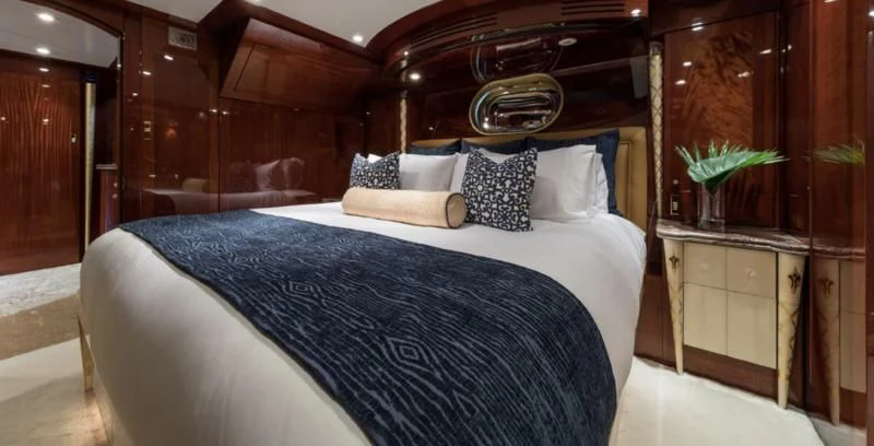a bed with white sheets and pillows aboard TOUCH Yacht for Sale