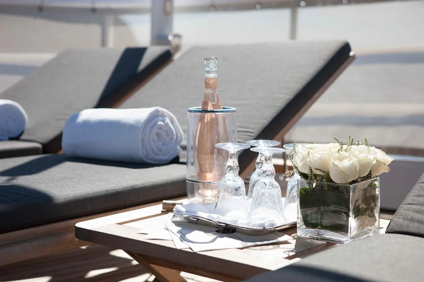 a table with a glass bottle and flowers on it aboard ICE LADY Yacht for Sale