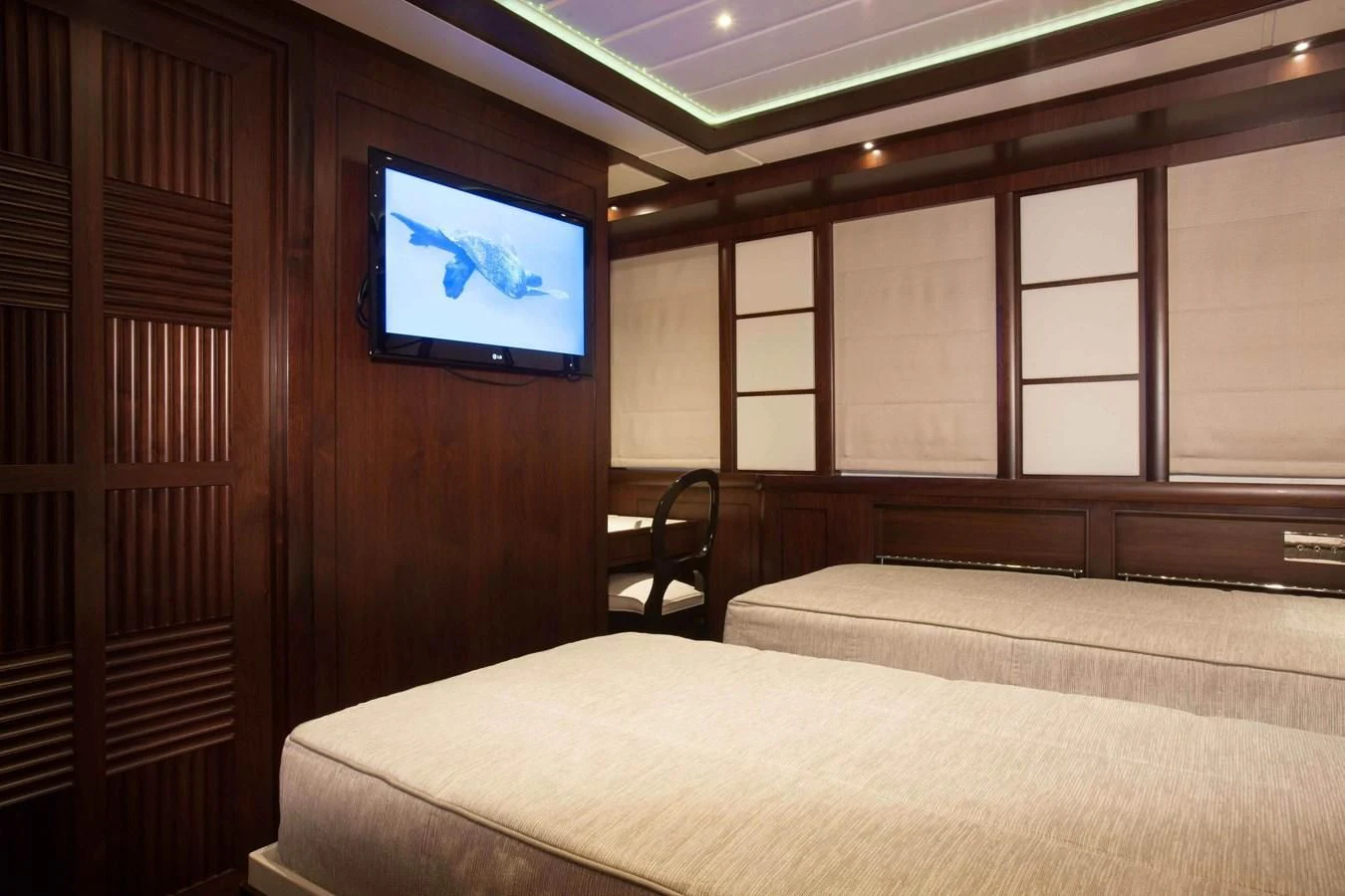 a room with a bed and a tv on the wall aboard ICE LADY Yacht for Sale