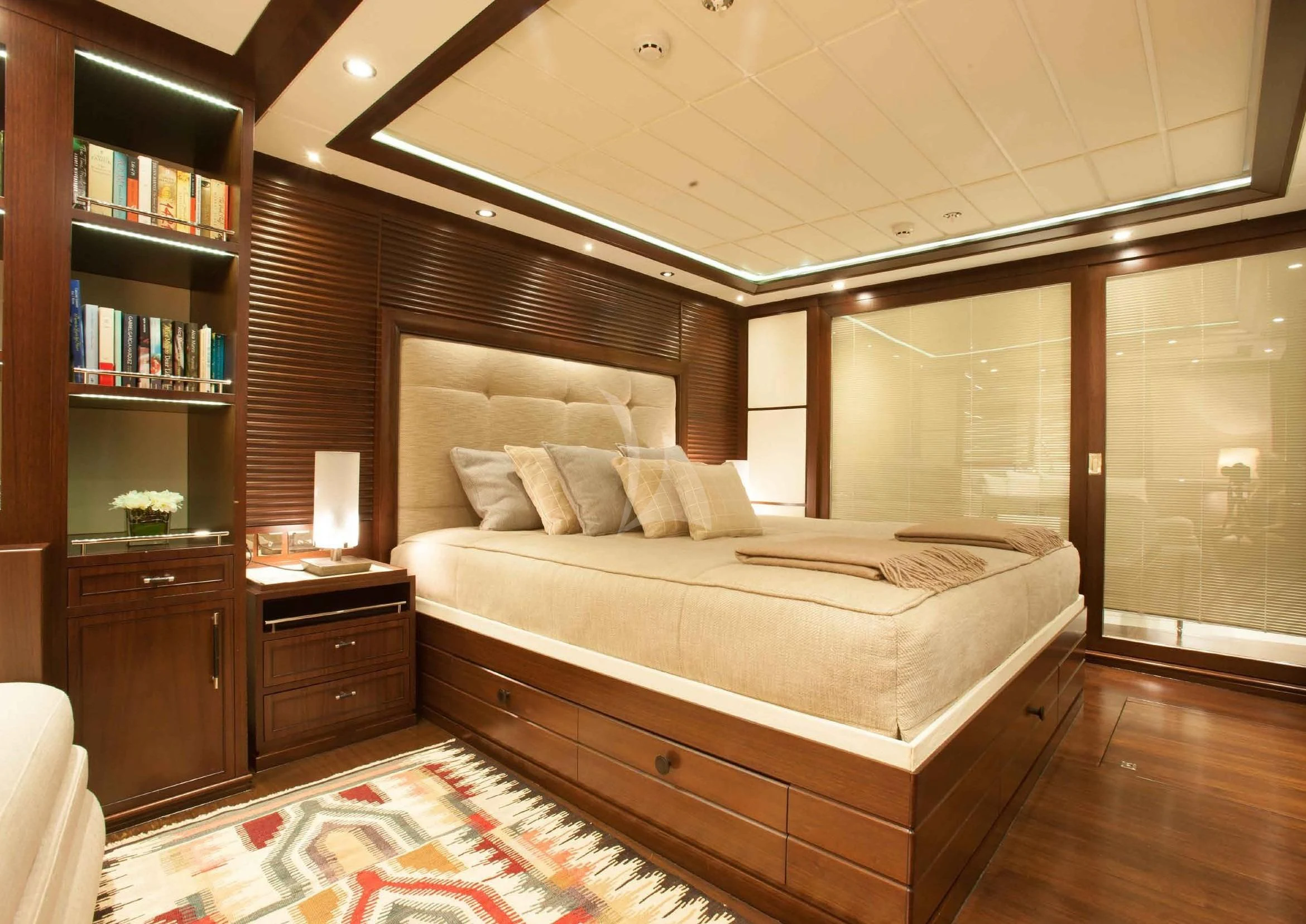 a bedroom with a bed and a bookcase aboard ICE LADY Yacht for Sale