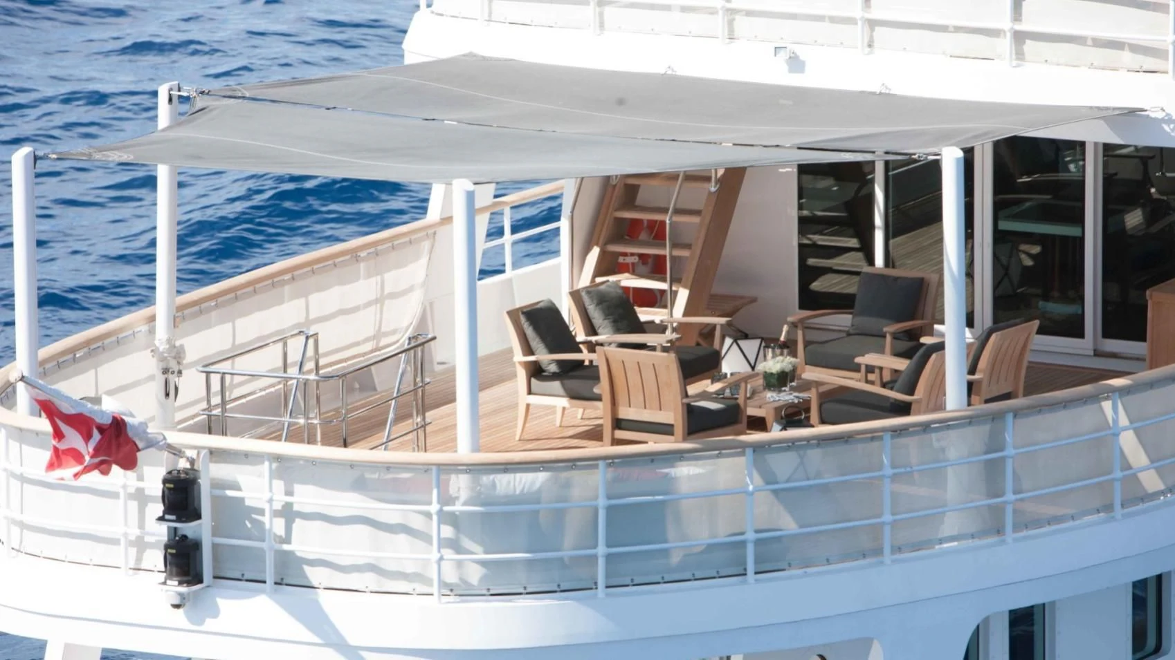 a large white boat with chairs and tables on the deck aboard ICE LADY Yacht for Sale