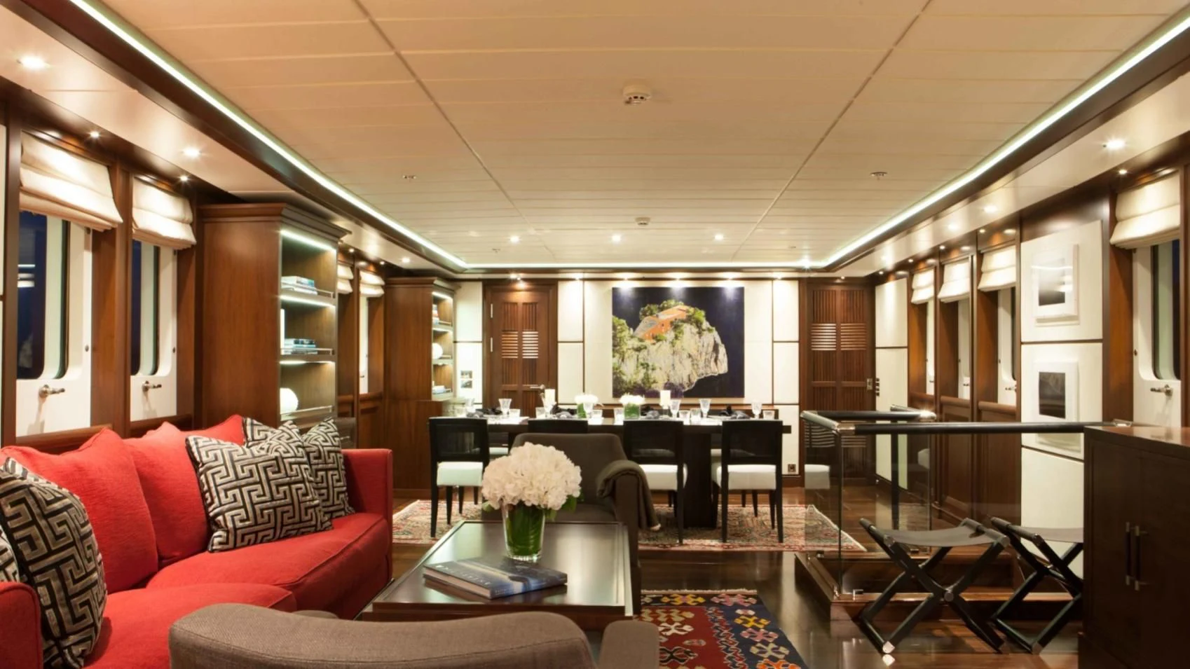 a living room with a red couch and a table aboard ICE LADY Yacht for Sale