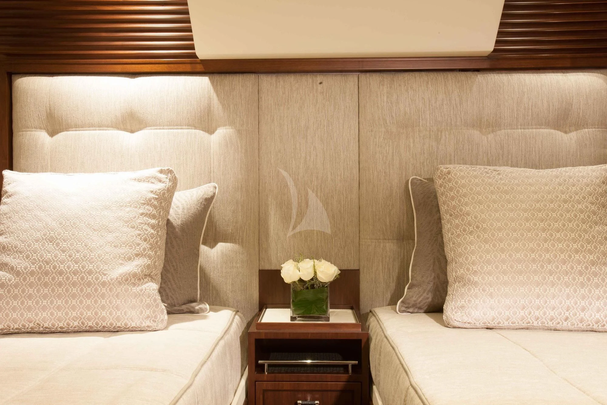 a couch with pillows and a vase of flowers on it aboard ICE LADY Yacht for Sale