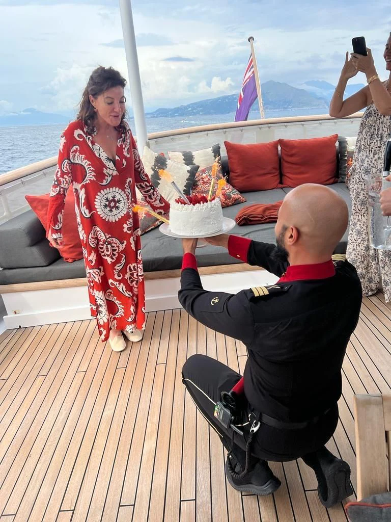 a man and a woman sitting on a bench with a woman holding a baby aboard ICE LADY Yacht for Sale