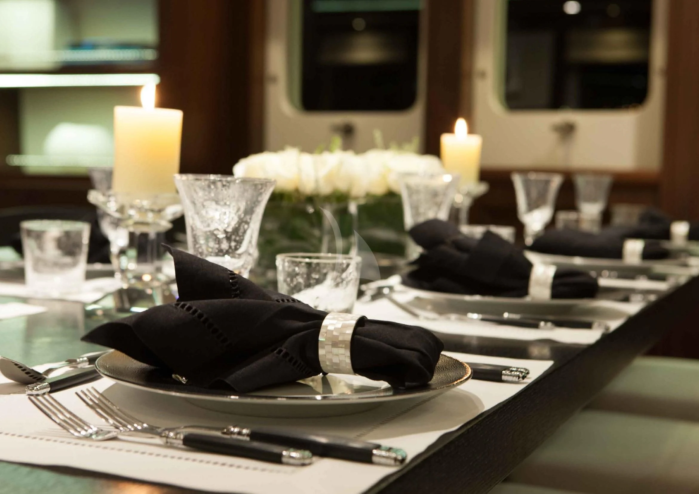 a table with a plate of food and candles on it aboard ICE LADY Yacht for Sale