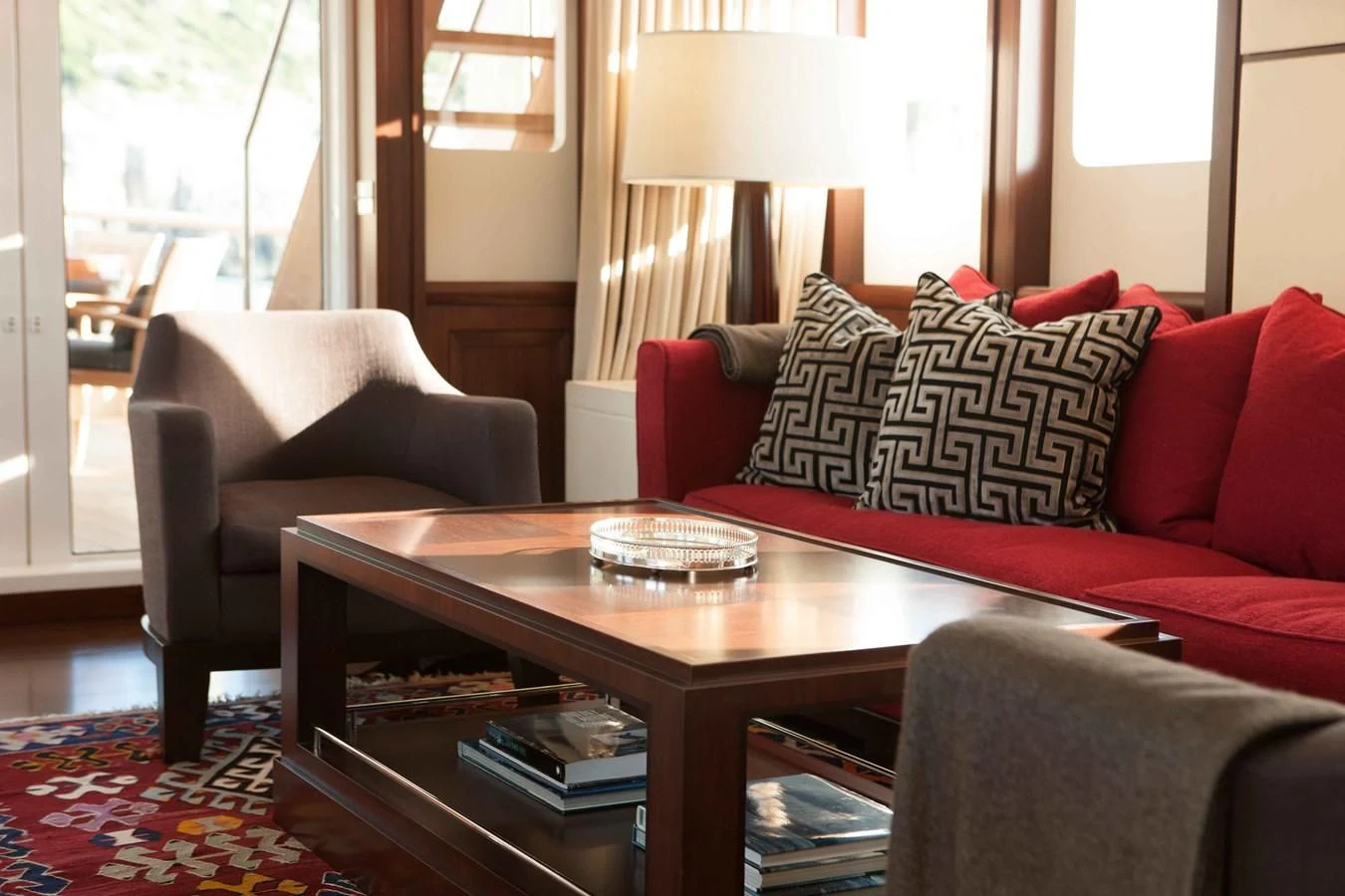 a living room with a red couch and a coffee table aboard ICE LADY Yacht for Sale