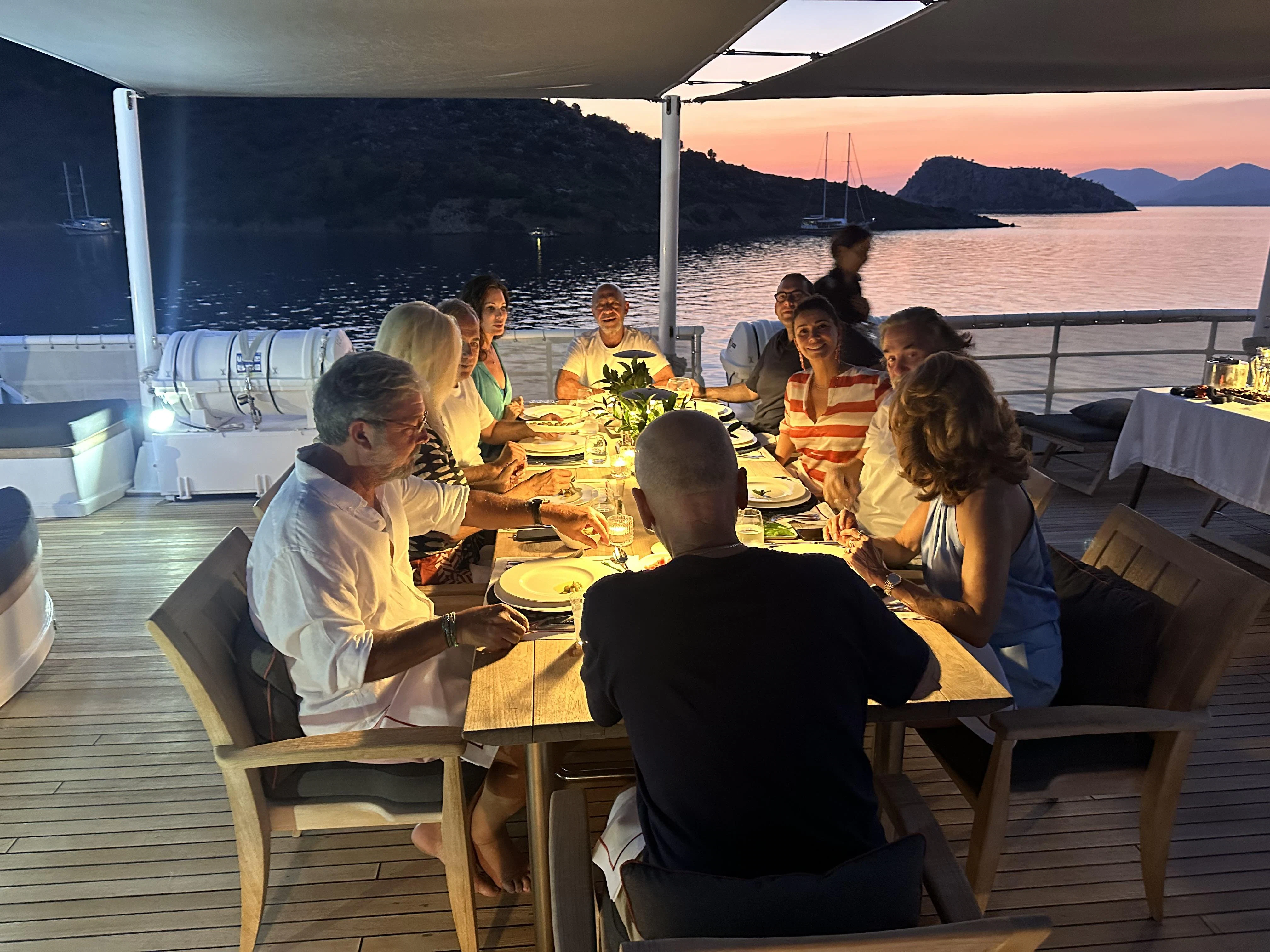 a group of people eating at a table aboard ICE LADY Yacht for Sale