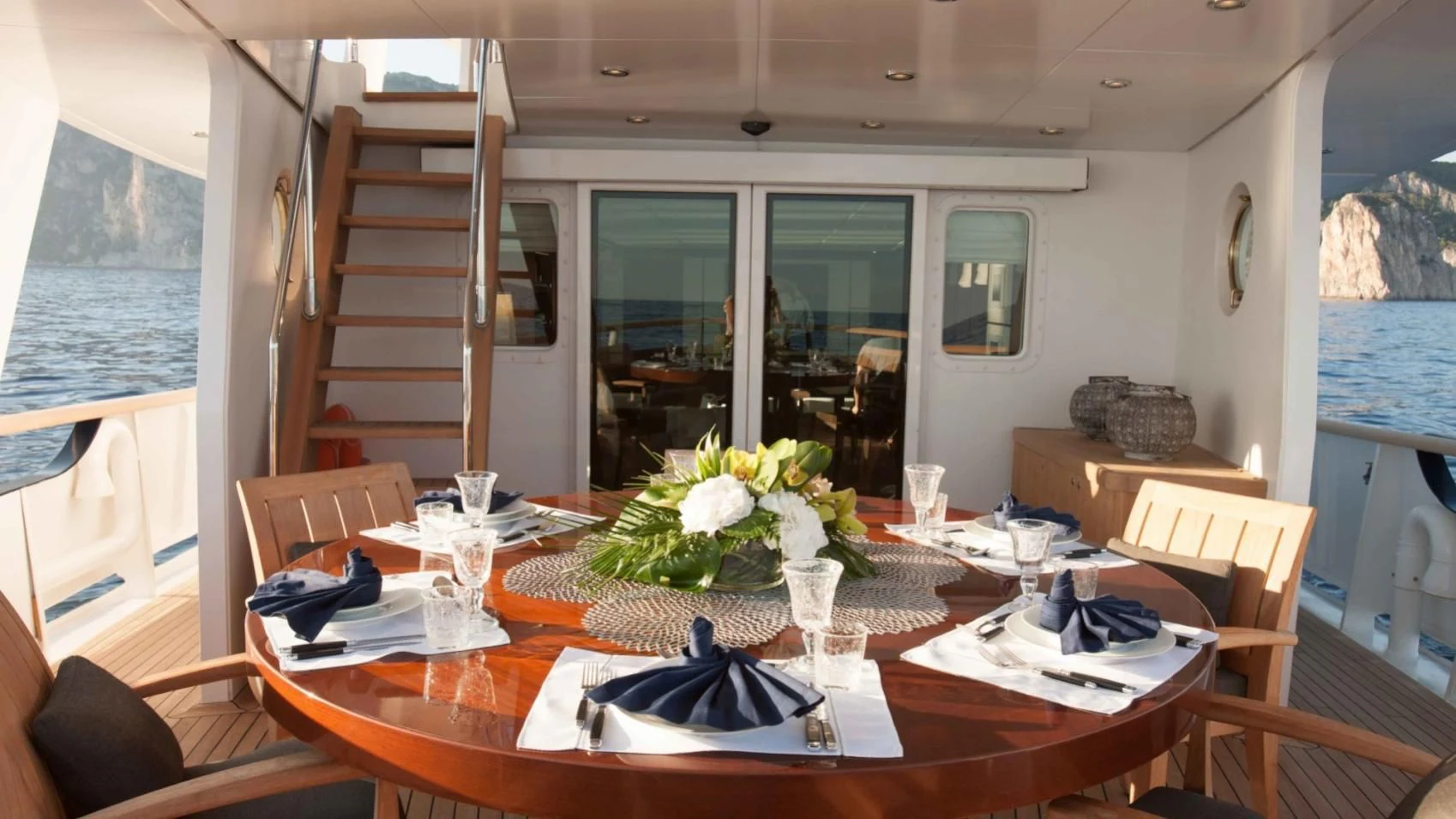 a dining table with chairs and a view of the ocean aboard ICE LADY Yacht for Sale