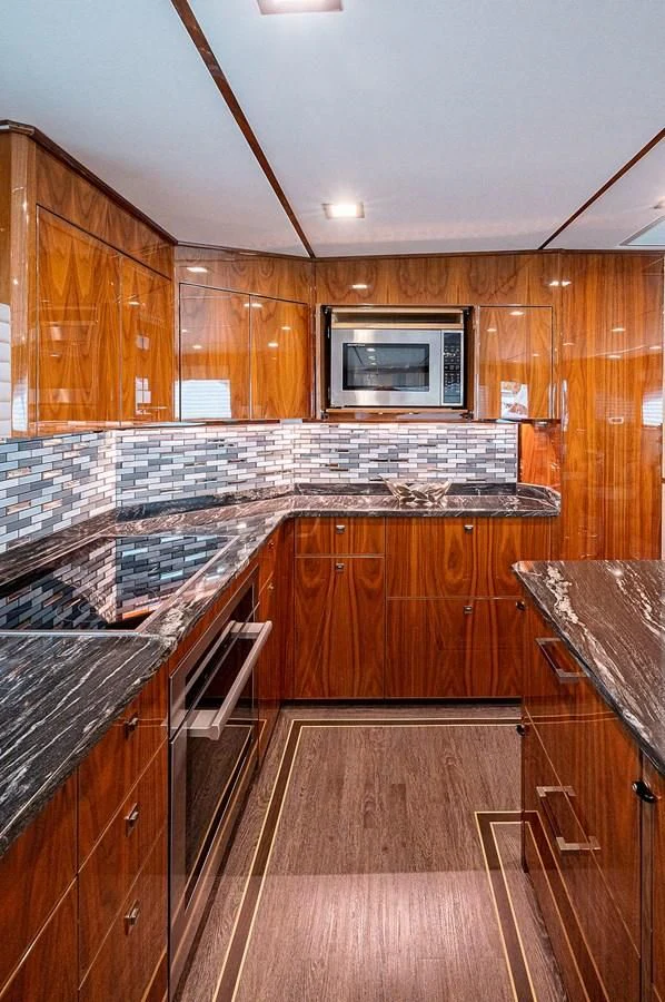 a kitchen with wooden cabinets aboard SURFBUM Yacht for Sale