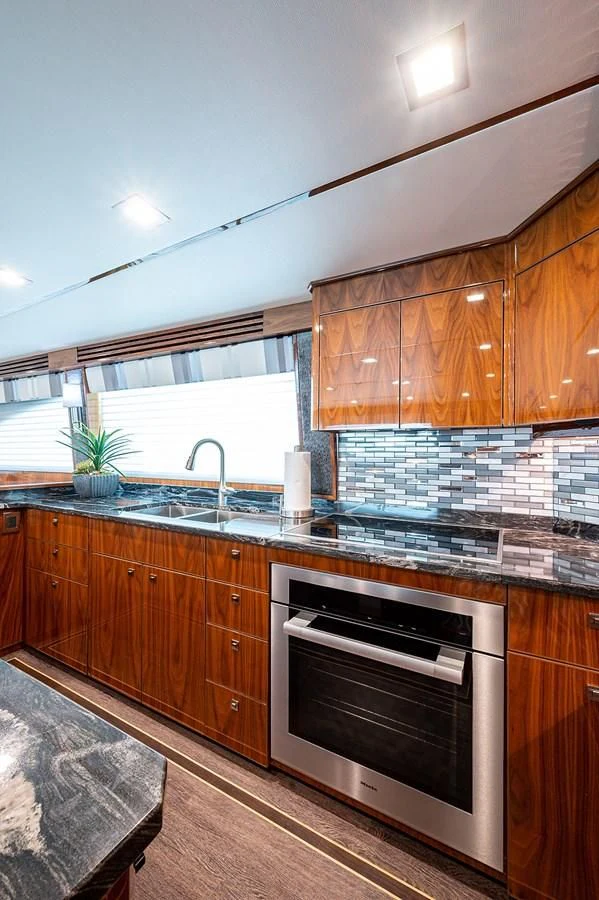 a kitchen with wooden cabinets aboard SURFBUM Yacht for Sale