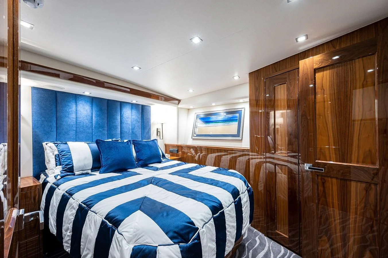 a bedroom with a bed and a wood cabinet aboard SURFBUM Yacht for Sale