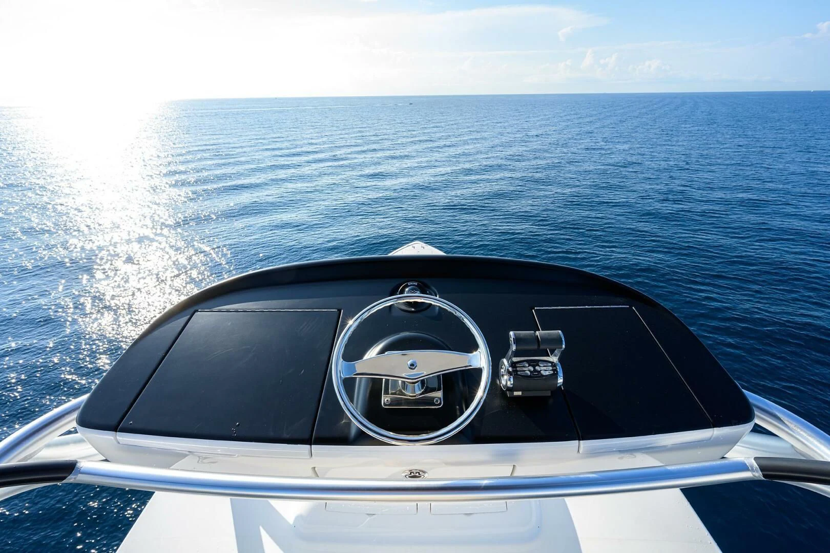 the front of a car with a steering wheel and a body of water in the background aboard SURFBUM Yacht for Sale