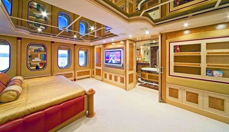 a room with a bed and a couch aboard SENSATION Yacht for Sale