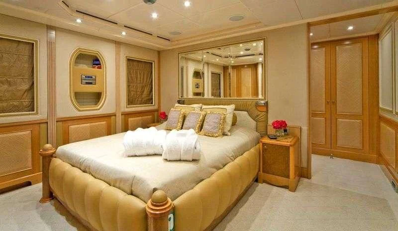 a bedroom with a bed and a mirror aboard SENSATION Yacht for Sale