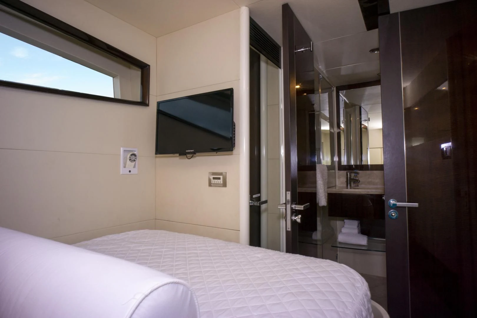 a hotel room with a bed and a television aboard SALACIA Yacht for Sale