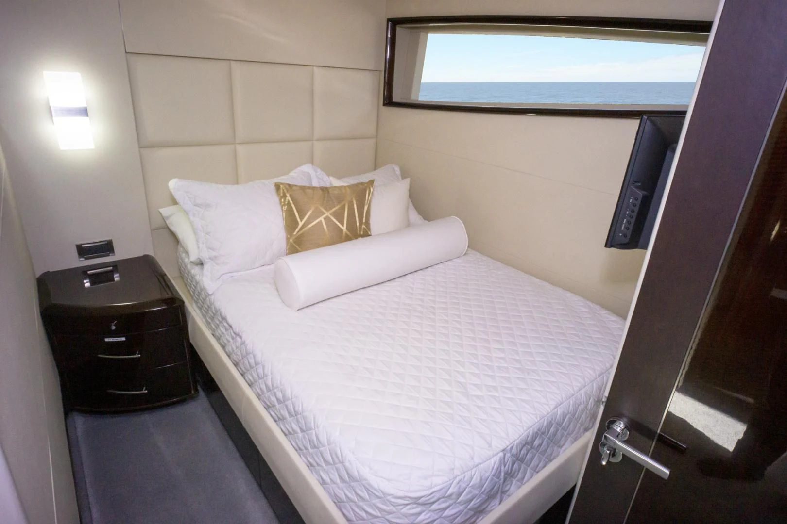 a bed with a white sheet and a black headboard aboard SALACIA Yacht for Sale