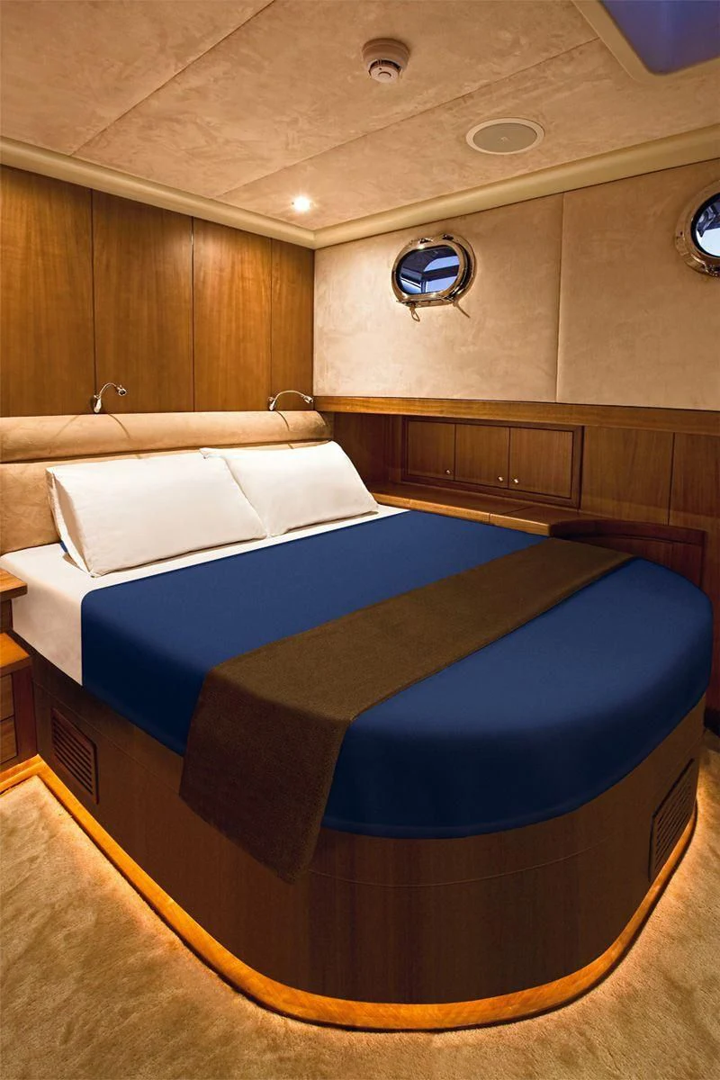 a bed with a blue sheet aboard MISS B Yacht for Sale