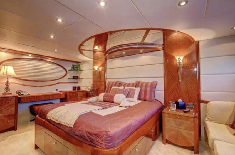 a bedroom with a bed and a chair aboard NO RULES Yacht for Sale