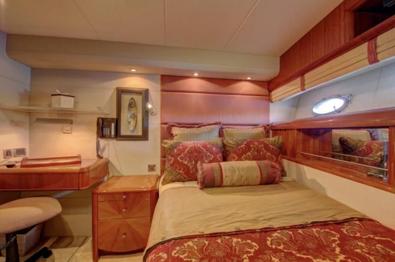 a bedroom with a bed and a desk aboard NO RULES Yacht for Sale