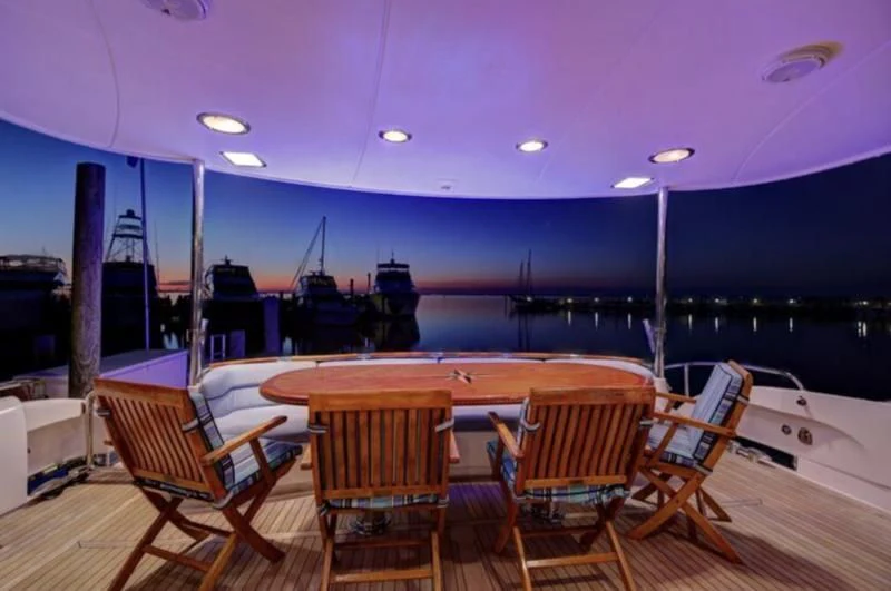 a table and chairs on a deck aboard NO RULES Yacht for Sale