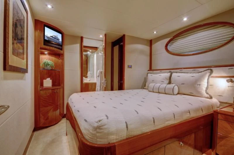 a bed with a white sheet and a red door aboard NO RULES Yacht for Sale