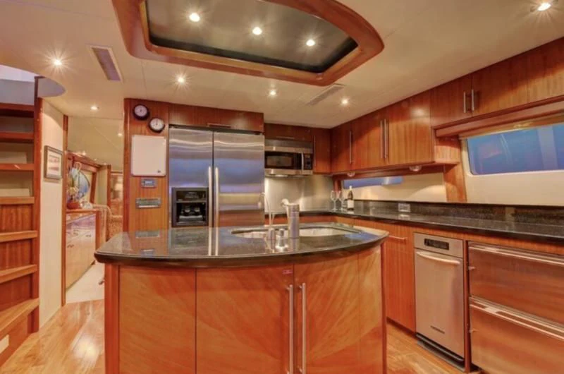 a kitchen with wooden cabinets aboard NO RULES Yacht for Sale