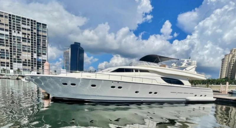 a white yacht in a body of water with buildings in the background aboard RABBIT Yacht for Sale