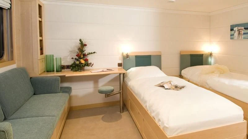 a room with a bed and a couch aboard HANSE EXPLORER Yacht for Sale