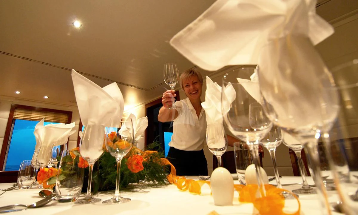 a person holding a wine glass aboard HANSE EXPLORER Yacht for Sale