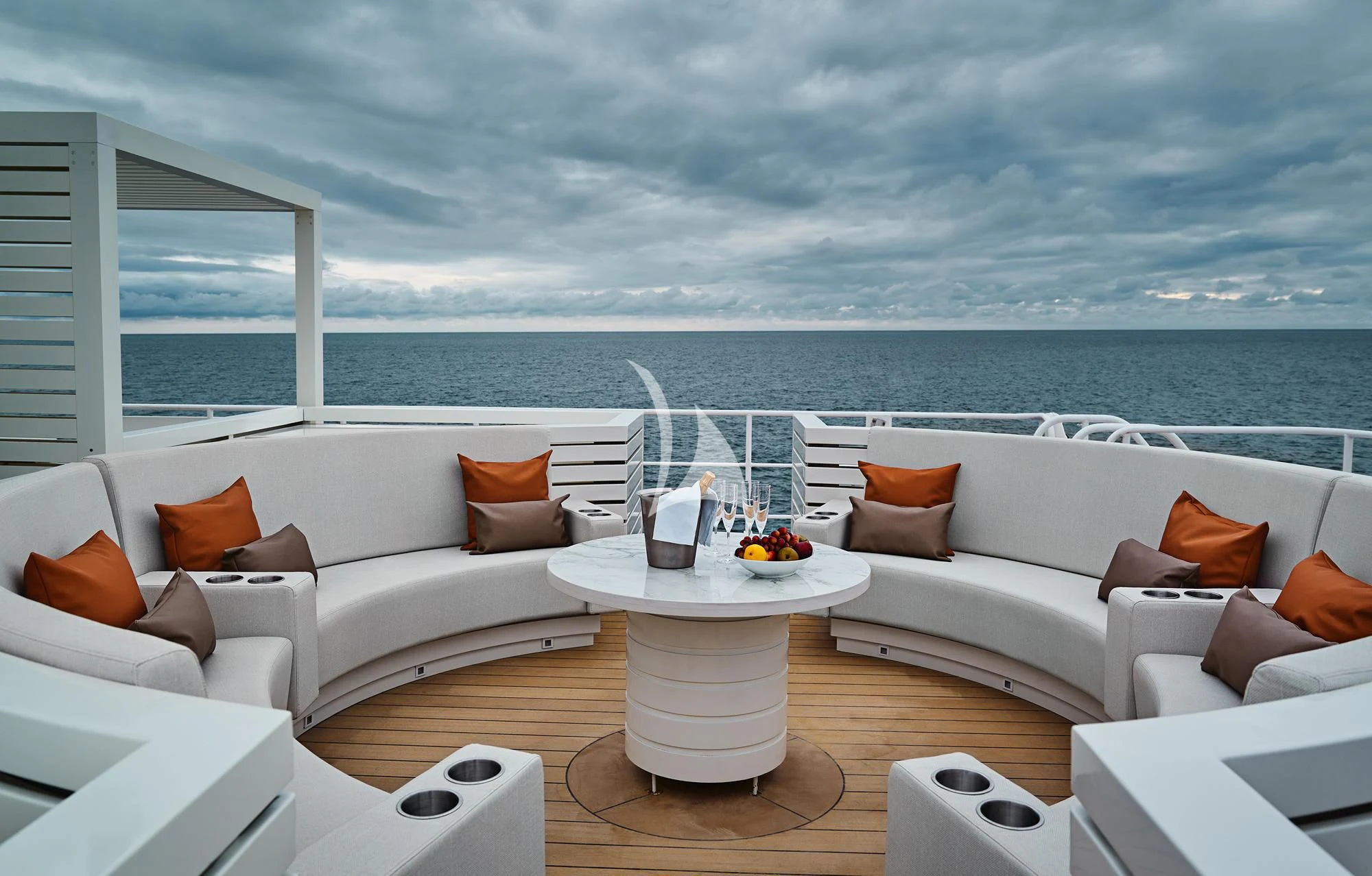 a room with a couch and a table with chairs and a large body of water in the background aboard HANSE EXPLORER Yacht for Sale