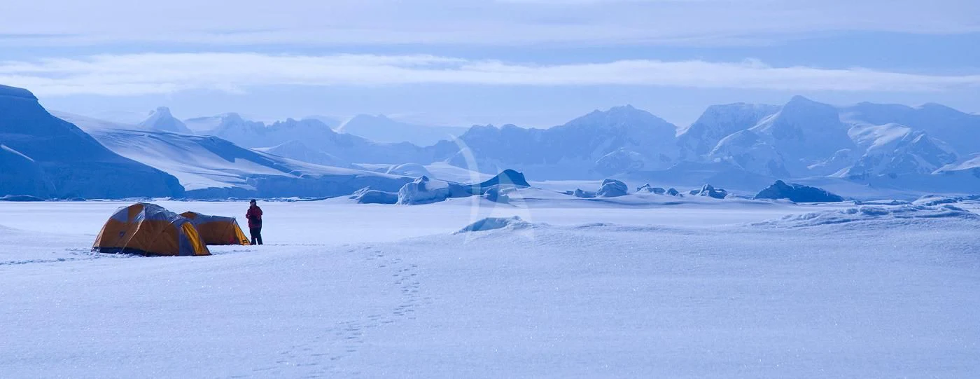 a person standing next to tents in a snowy landscape aboard HANSE EXPLORER Yacht for Sale