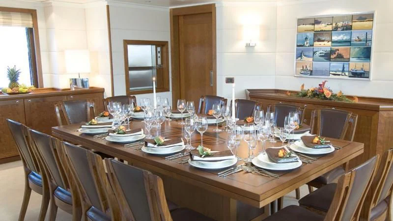a large dining table with plates and glasses on it aboard HANSE EXPLORER Yacht for Sale