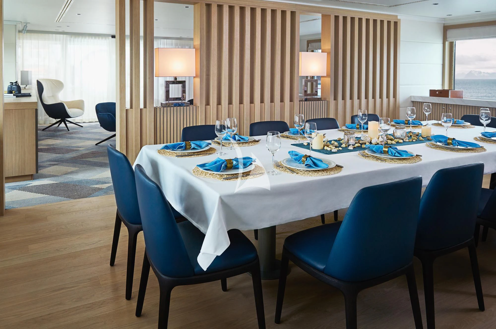 a large dining table with blue chairs aboard HANSE EXPLORER Yacht for Sale