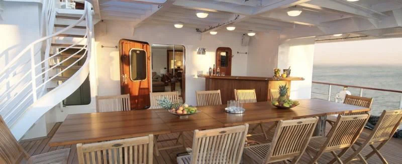 a large room with a table and chairs and a balcony aboard HANSE EXPLORER Yacht for Sale